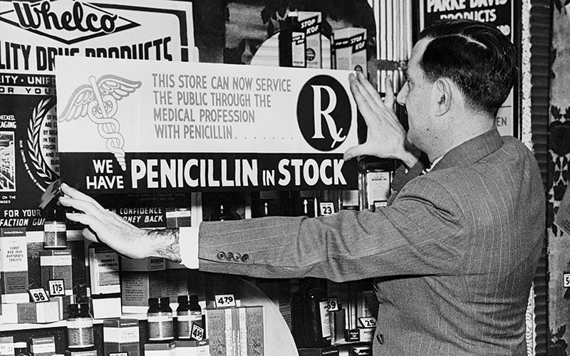 Pharmacist Placing Sign in store Getty
